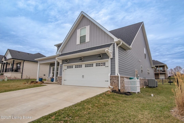 view of front of house featuring a front yard, fence, driveway, an attached garage, and central AC