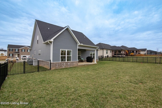 back of property featuring brick siding, a fenced backyard, a patio area, and a yard