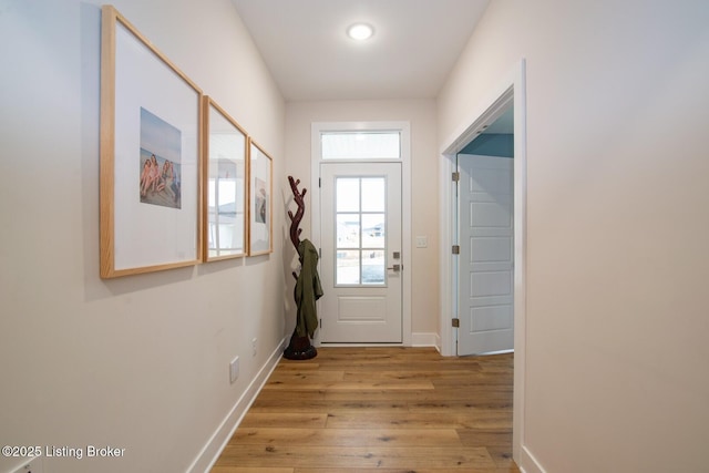 doorway with baseboards and light wood-style floors