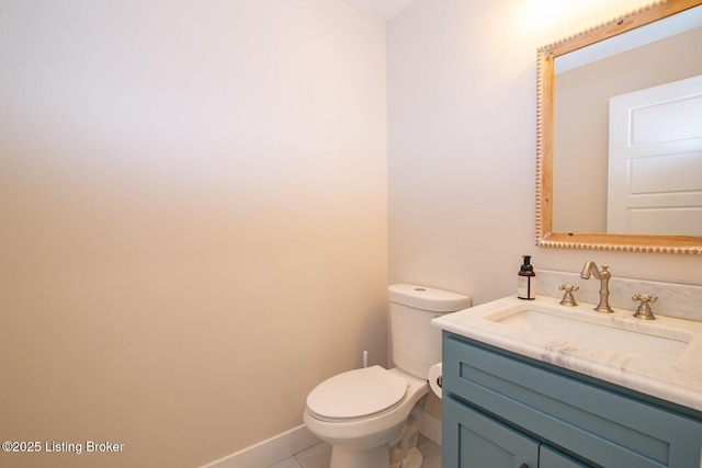 bathroom with baseboards, toilet, vanity, and tile patterned flooring