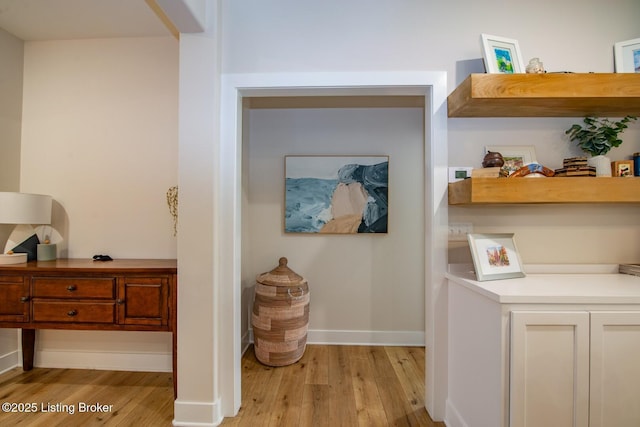 interior space featuring baseboards and light wood-style floors