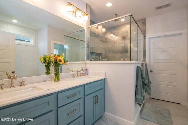 bathroom featuring double vanity, recessed lighting, a stall shower, and a sink