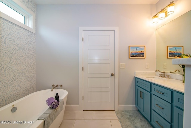 bathroom featuring baseboards, a freestanding bath, vanity, and tile patterned flooring