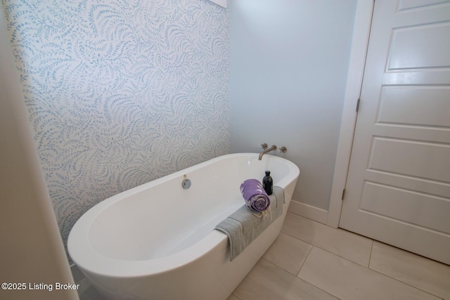 full bathroom with tile patterned floors, baseboards, and a freestanding bath