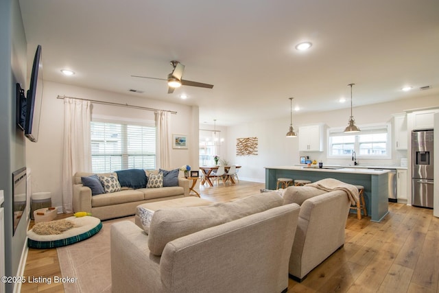 living room featuring light wood finished floors, visible vents, and recessed lighting