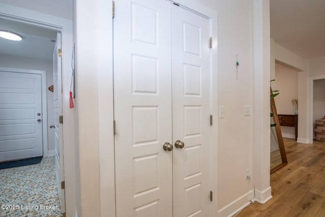 hall with baseboards and light wood-style flooring