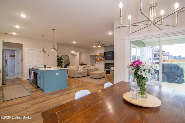 dining area featuring recessed lighting, visible vents, light wood-style floors, and ceiling fan with notable chandelier