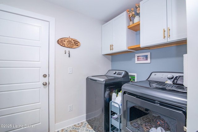 laundry room featuring washer and dryer, cabinet space, and baseboards