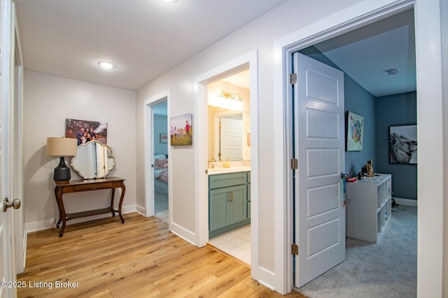 hall with baseboards and light wood finished floors