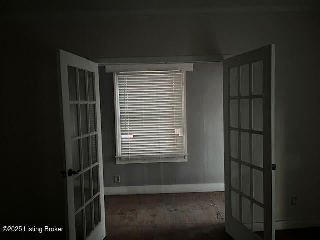 unfurnished room featuring french doors and baseboards
