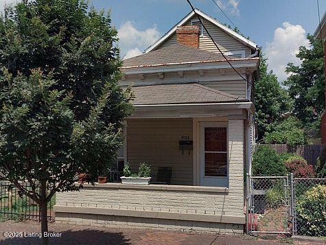 view of front of home featuring covered porch, fence, and a gate