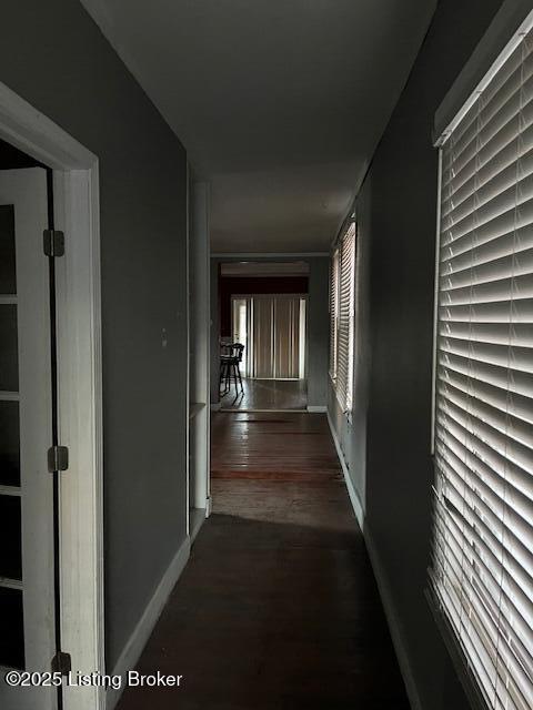 corridor with baseboards and dark wood-type flooring