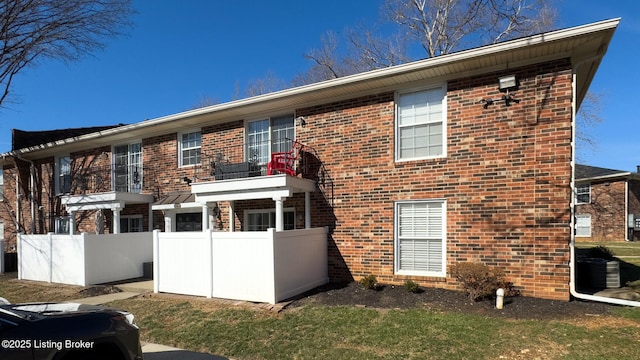 exterior space featuring brick siding and fence