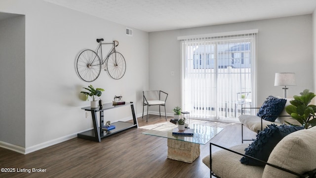 sitting room with baseboards, a textured ceiling, visible vents, and wood finished floors