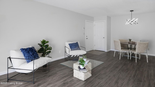 interior space featuring baseboards, wood finished floors, and an inviting chandelier