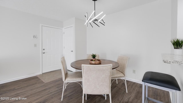 dining area with baseboards, a notable chandelier, and wood finished floors