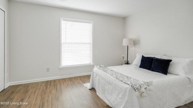 bedroom featuring baseboards and wood finished floors