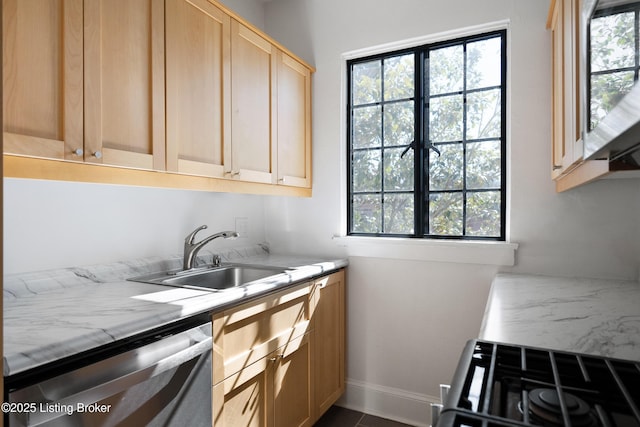 kitchen featuring dishwasher, gas range oven, light countertops, light brown cabinets, and a sink