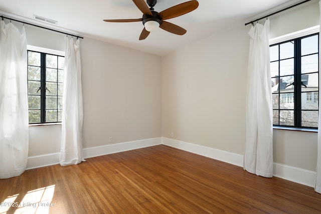 spare room with baseboards, visible vents, ceiling fan, and light wood finished floors