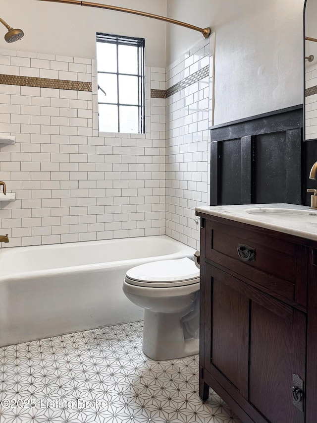 bathroom featuring toilet, vanity, and shower / tub combination