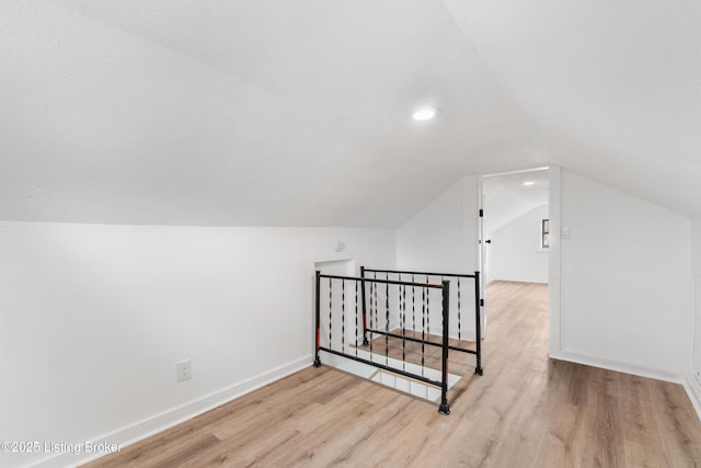 bonus room with lofted ceiling, baseboards, wood finished floors, and recessed lighting