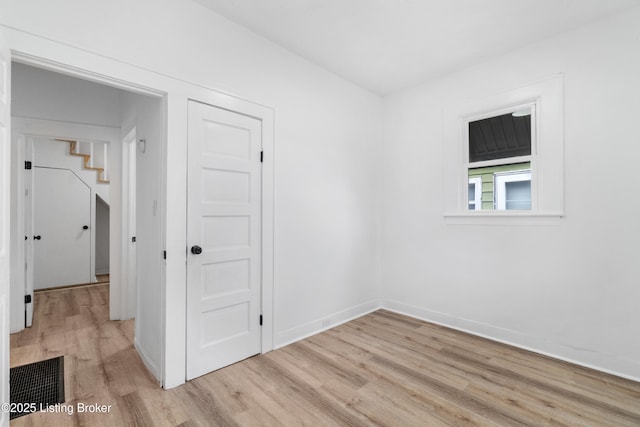 empty room with light wood-type flooring and baseboards