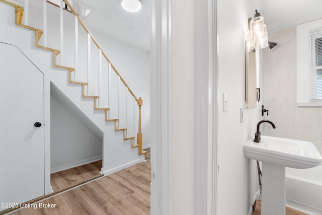 bathroom with a sink, baseboards, and wood finished floors