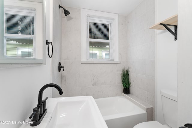 bathroom with toilet, a tub to relax in, a shower, and a sink