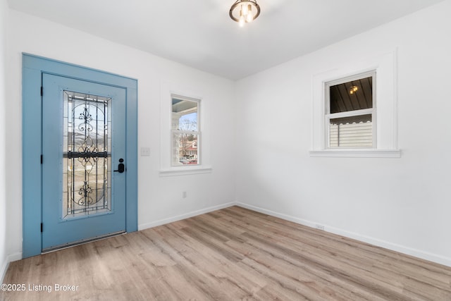 foyer with a healthy amount of sunlight, baseboards, and wood finished floors