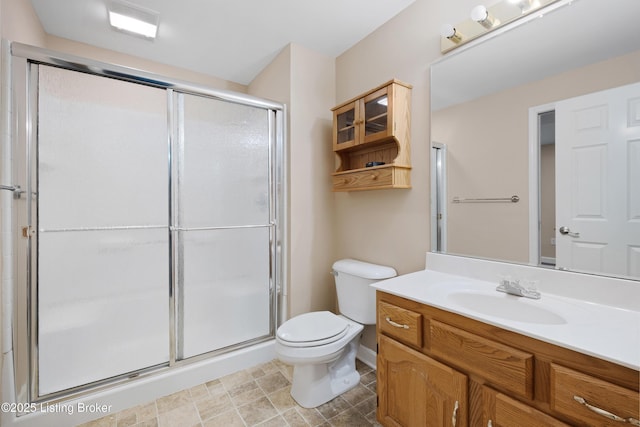 bathroom featuring a stall shower, vanity, and toilet