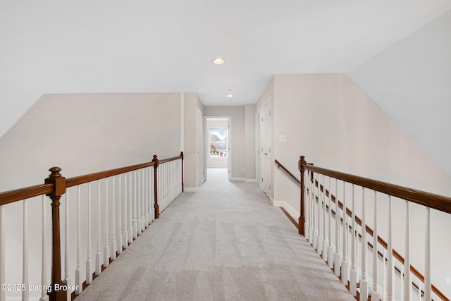 hallway featuring recessed lighting, baseboards, carpet flooring, and an upstairs landing