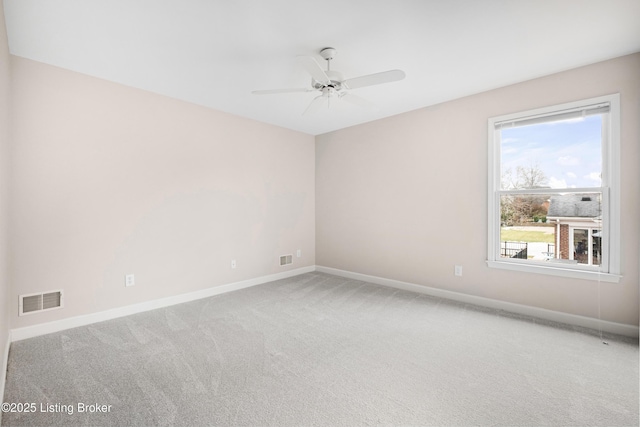 spare room with a ceiling fan, carpet, visible vents, and baseboards