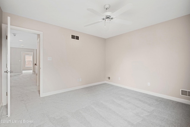 empty room with light carpet, baseboards, visible vents, and a ceiling fan