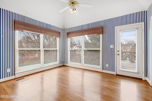 interior space featuring a ceiling fan, visible vents, and vaulted ceiling