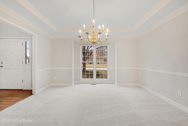 unfurnished dining area featuring a notable chandelier, crown molding, baseboards, and carpet flooring