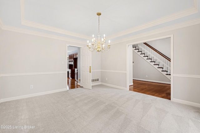 spare room featuring carpet floors, visible vents, a tray ceiling, and baseboards