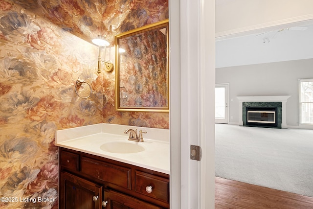 bathroom with a high end fireplace, vanity, and wallpapered walls