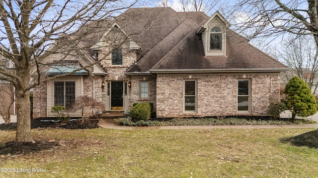 view of front of home with brick siding, a front lawn, and roof with shingles