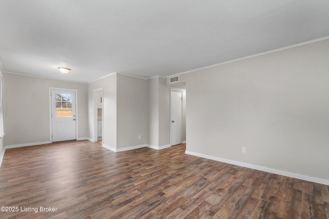 unfurnished room with visible vents, ornamental molding, baseboards, and wood finished floors