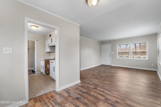 unfurnished room with crown molding, dark wood-style floors, and baseboards