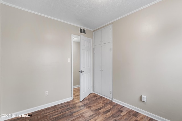 unfurnished bedroom with visible vents, dark wood-type flooring, baseboards, a closet, and a textured ceiling