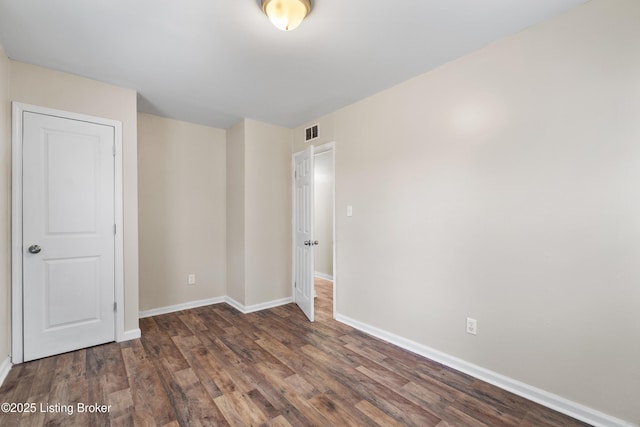 unfurnished bedroom featuring visible vents, baseboards, and wood finished floors