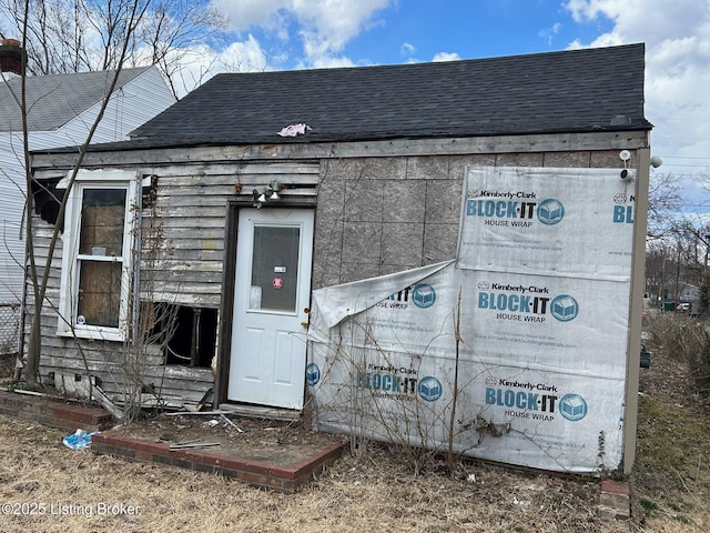 exterior space featuring a shingled roof