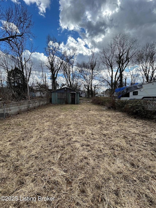 view of yard with fence and an outdoor structure