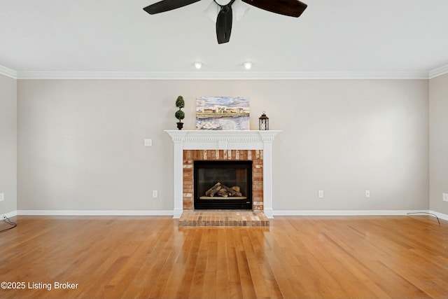 unfurnished living room with a fireplace, light wood finished floors, ornamental molding, ceiling fan, and baseboards