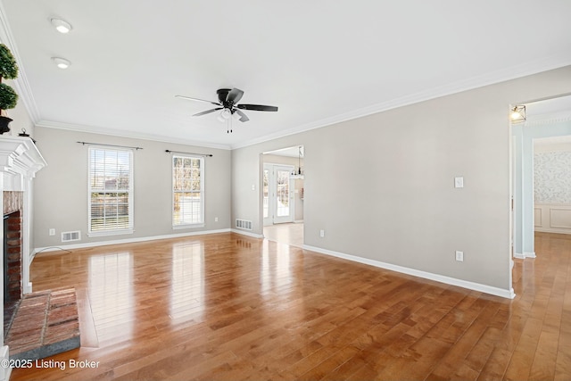 unfurnished living room with crown molding, a brick fireplace, visible vents, and light wood-style floors