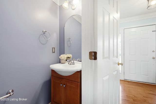 bathroom featuring vanity, crown molding, and wood finished floors