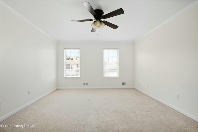 empty room featuring light colored carpet, visible vents, ornamental molding, a ceiling fan, and baseboards