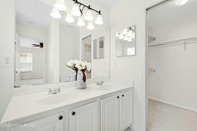 bathroom featuring double vanity, a spacious closet, a sink, and visible vents