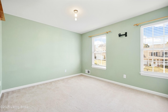 carpeted empty room with visible vents and baseboards